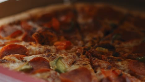 pizza de pepperoni con pimientos verdes en una caja de cartón