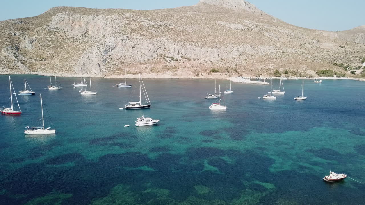 Grecia, Isola di Leros, Baia di Xirocampos. Riprese drone in una giornata di sole. Le riprese iniziano dall'ingresso della baia e si dirigono verso la spiaggia e la splendida città con case bianche. Baia cristallina.