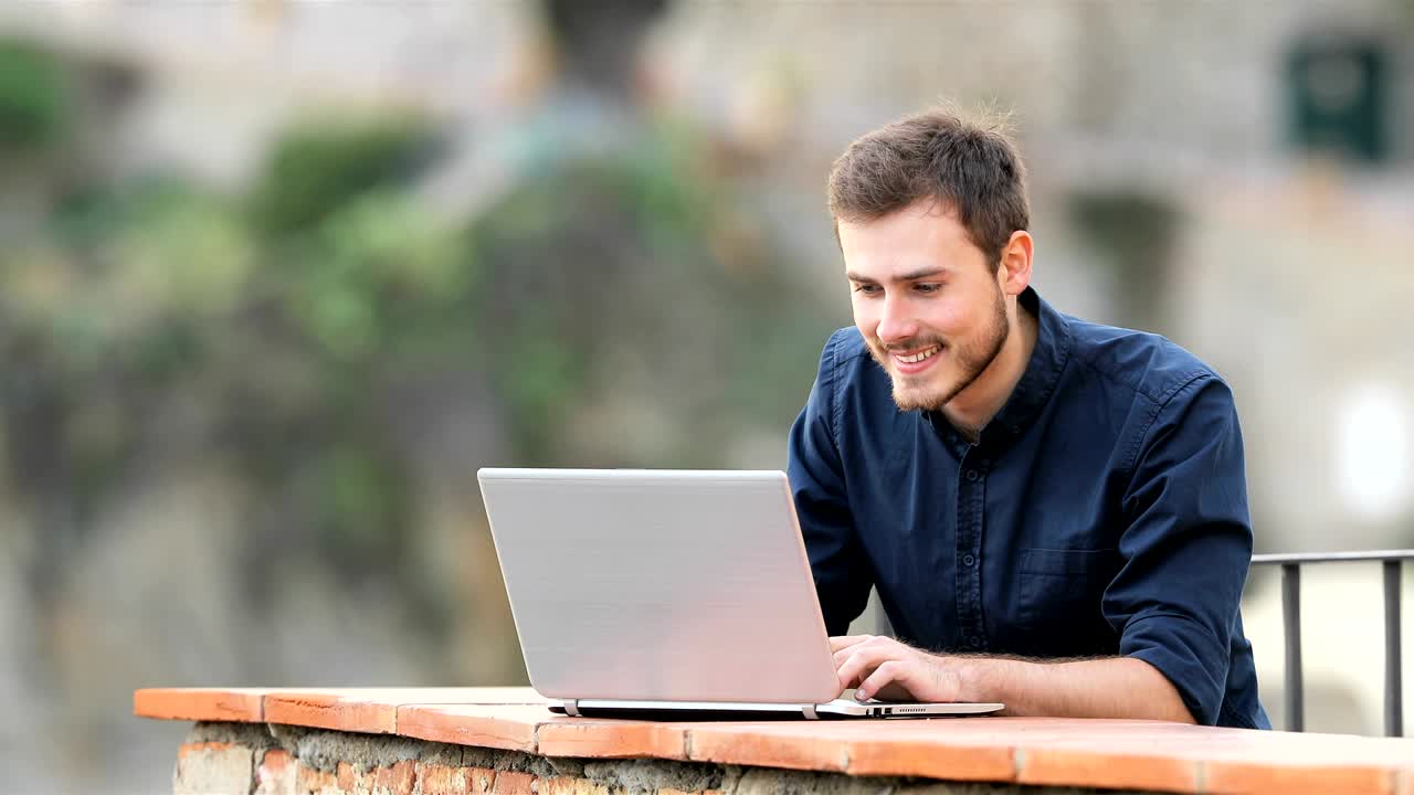 hombre emocionado encontrando contenido en línea en una computadora portátil