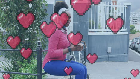 animación de corazones de píxeles sobre una feliz mujer afroamericana con máscara facial comiendo en la calle