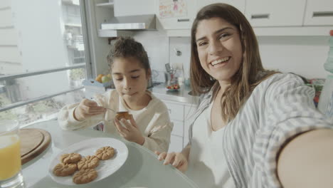 pov happy mom and daughter video calling over breakfast at home
