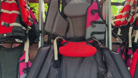 panning shot of a rack with life vests for watersports