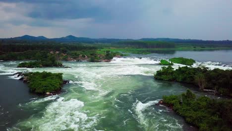 aerial view of the river nile's powerful rapids flowing through a vibrant green landscape under a dramatic sky in uganda, africa, showcase the raw beauty and force of nature, revel orbiting drone shot