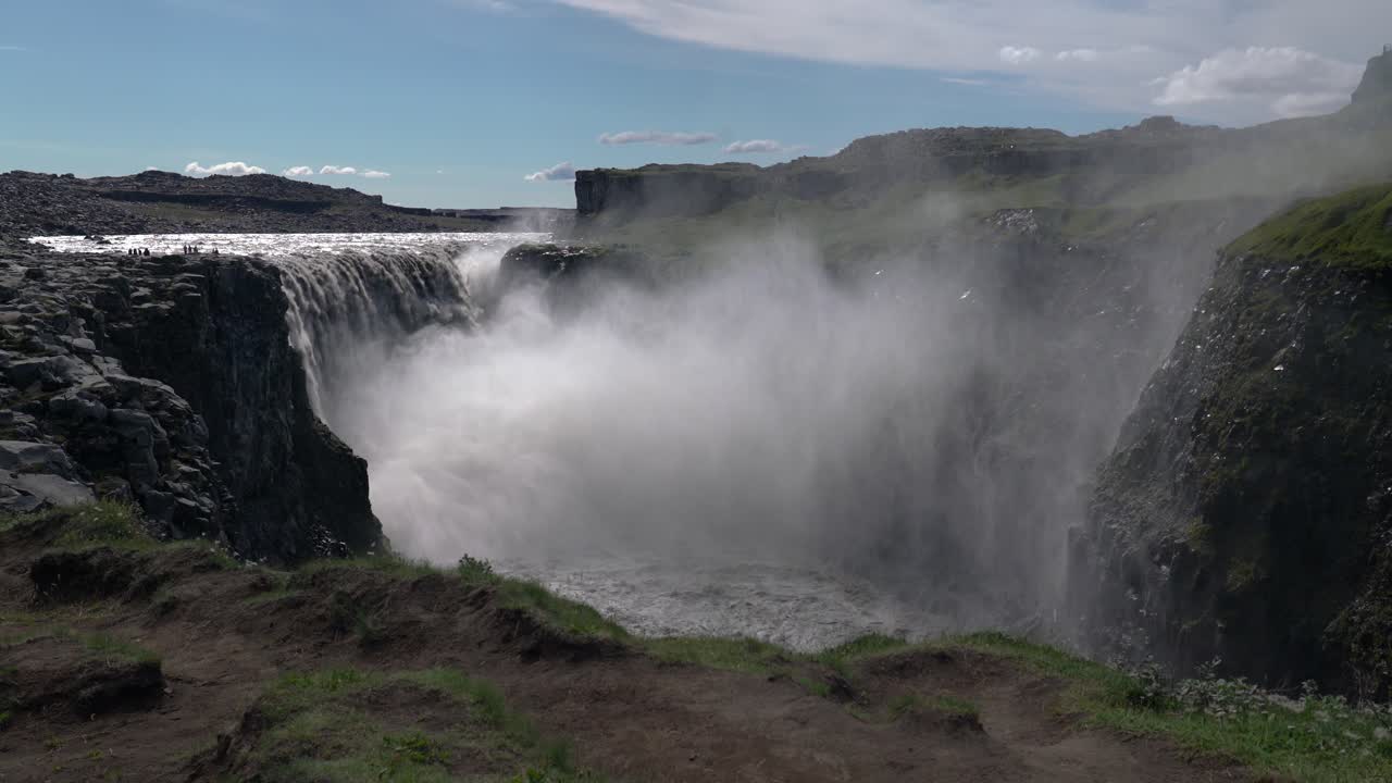 espectacular plano general de la hermosa cascada dettifoss rociando y salpicando durante la luz del sol en la isla de islandia