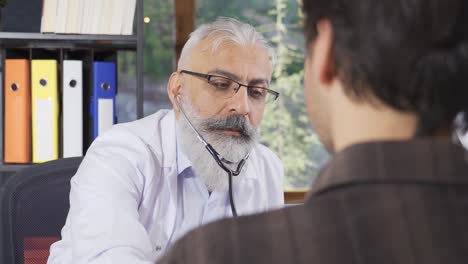 el médico sénior examinando con un estetoscopio.