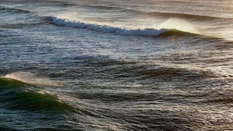 Golden-sunlight-reflecting-on-tumultuous-ocean-waves,-The-sea's-surface-glistening-at-sunset