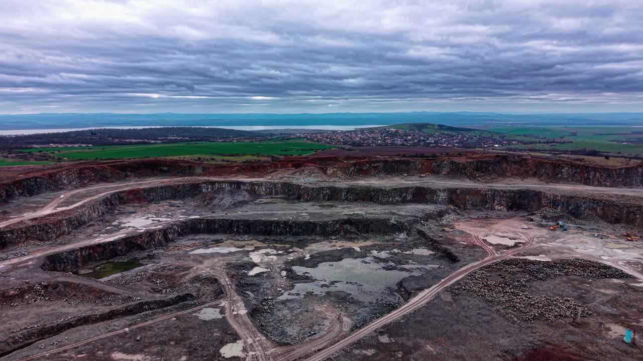 Granite quarry landscape with machinery and hills in background