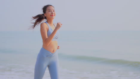 healthy young woman jogging along the ocean keeping an active lifestyle and staying fit