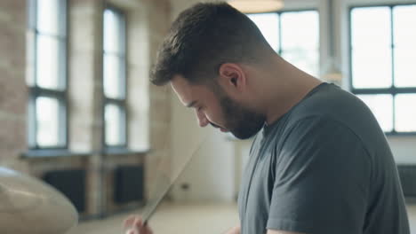 musician playing drum set while rehearsing in studio