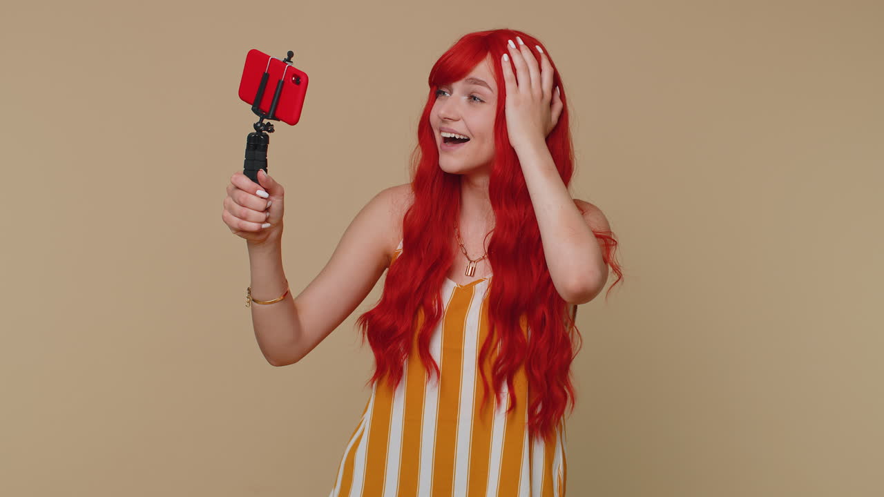 blogger chica tomar selfie en el teléfono móvil selfie stick comunicarse llamada de video en línea con los suscriptores