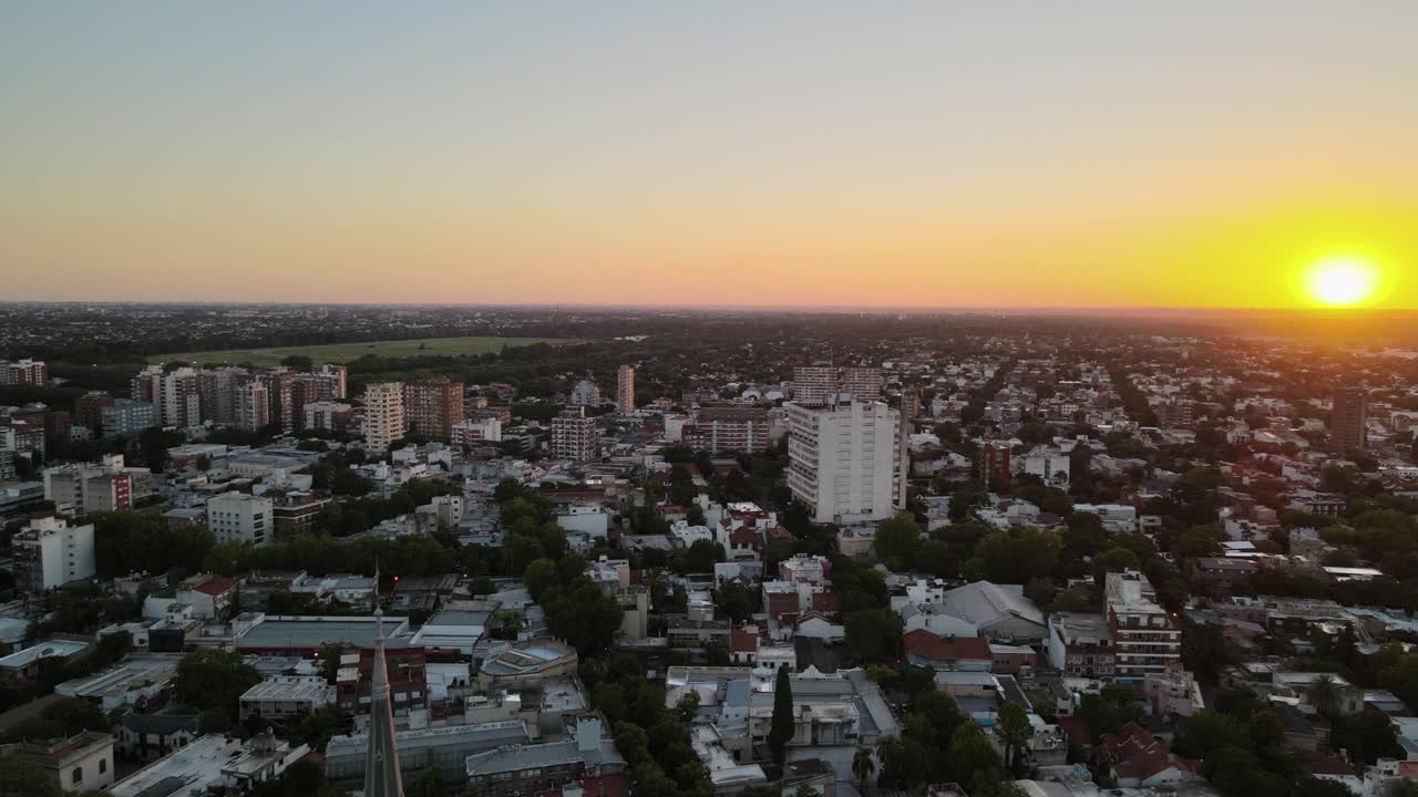 toma aérea que se eleva detrás de la aguja de la catedral y revela la puesta de sol en el vecindario