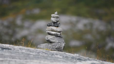 a stack of stones, intricately balanced on top of each other, with a blurred natural background.