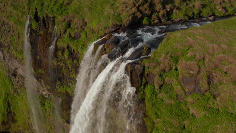 Drone-view-of-stunning-highlands-and-Seljalandsfoss-waterfall-in-southern-Iceland.-Birds-eye-view-of-water-flowing-from-most-touristic-cascade-in-icelandic-national-park