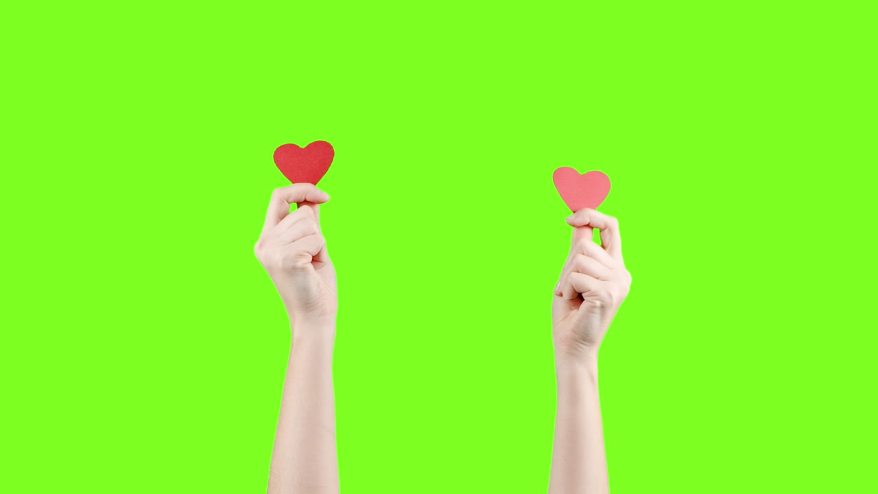 blogger mujer sostiene en la mano un pequeño corazón rojo en la pantalla verde. como en la red social. día de san valentín, día internacional de la mujer, amor
