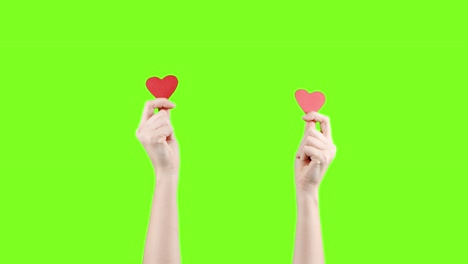 blogger mujer sostiene en la mano un pequeño corazón rojo en la pantalla verde. como en la red social. día de san valentín, día internacional de la mujer, amor