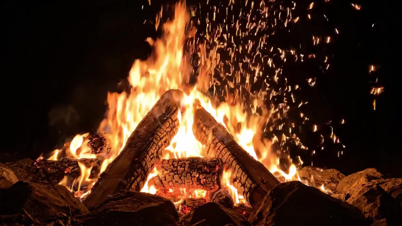 Una vista accattivante di un falò scoppiettante con fiamme danzanti e braci incandescenti che illuminano la notte, circondato da rocce e scintille intense