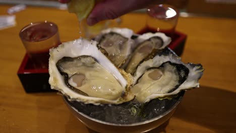 squeezing lemon juice on raw oysters