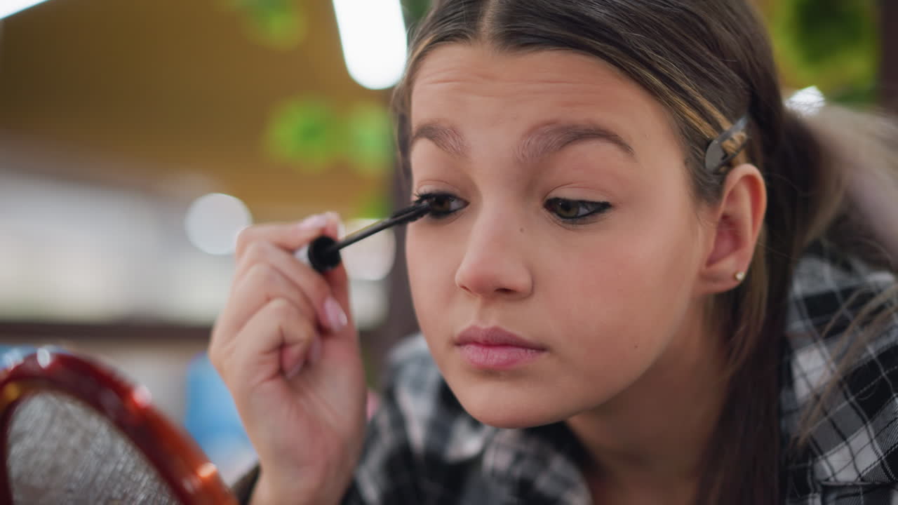 primer plano de una dama aplicando suavemente máscara a sus pestañas, centrándose en el delicado proceso de mejorar el volumen y la longitud de las pestañas para un aspecto perfecto de maquillaje de ojos usando una varita de máscara