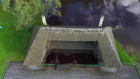 historic village performance stage near lake water, aerial view