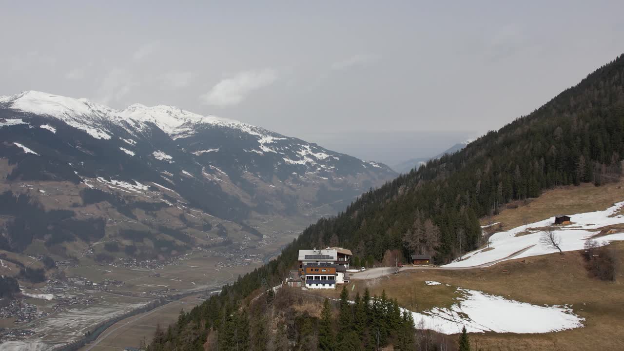 un refugio alpino en lo alto de los alpes austriacos llamado steiner kogl ofrece vistas panorámicas de un pintoresco valle cubierto de nieve y un encantador pueblo más abajo conocido como mayrhofen.