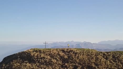 Camera-follows-a-young-trail-runner-with-a-yellow-shirt-who-puts-up-his-arms-to-celebrate-himself