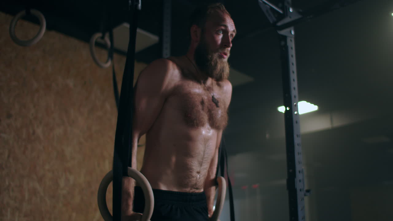 A man performs push-ups on gymnastic rings
