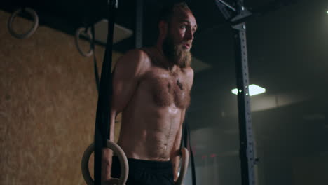 a man performs push-ups on gymnastic rings