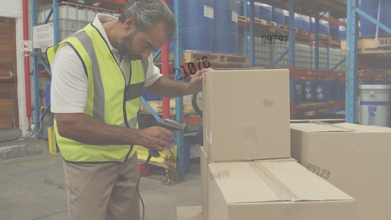Warehouse handler reaching for scanner, steadying stacked boxes and scanning labels for inventory
