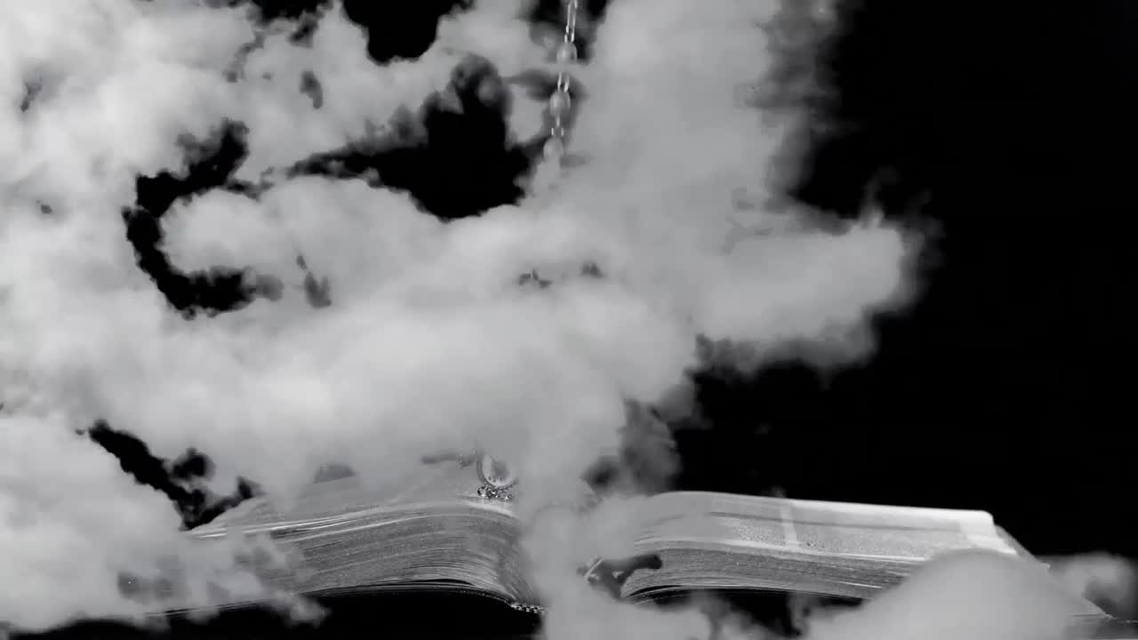 animación del rosario cristiano con la cruz cayendo en un libro abierto de la biblia sobre las nubes que se mueven en fa