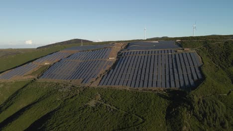 aerial view of a photovoltaic farm and a wind farm on top of a mountain in paul da serra madeira island