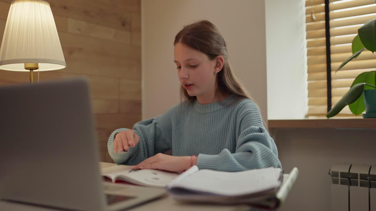 Teenage girl studying with laptop