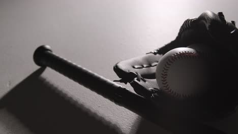 monochromatic close up studio baseball still life with bat ball and catchers mitt