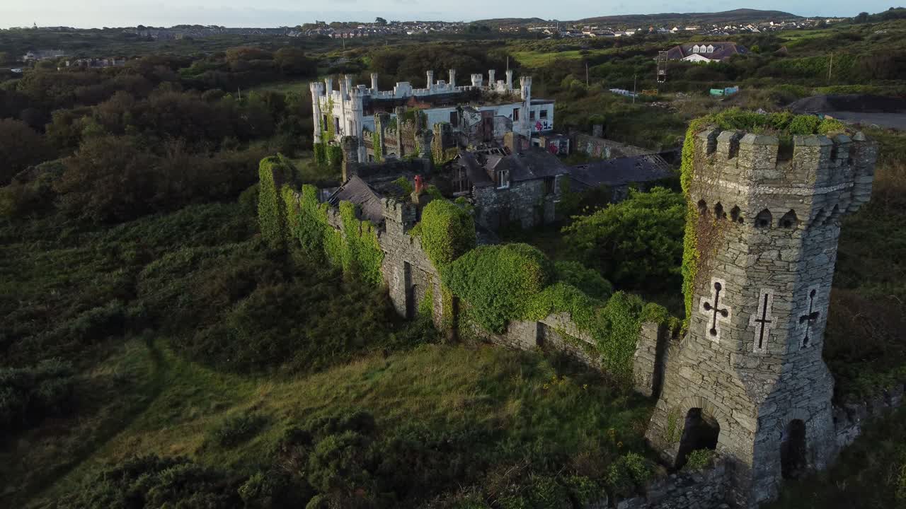 los soldados apuntan a la casa. vista aérea hacia la mansión abandonada del parque costero de holyhead.