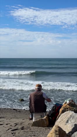 man sitting on the beach, ocean view