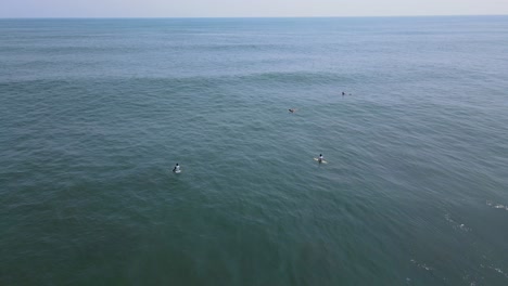 vista aérea completa, surfistas esperando las olas en la playa bitcoin en el salvador, méxico, cielo azul y día soleado en el fondo