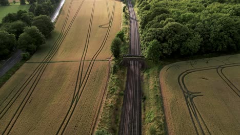 vista aérea del ferrocarril a lo largo de los campos con cultivos maduros listos para la cosecha en warminster, reino unido