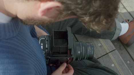 hipster photographer fixing a mamiya rb67 analog film camera - close up