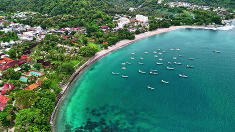 beautiful senggigi beach with clear turquoise water, boats, and homes surrounded by greenery