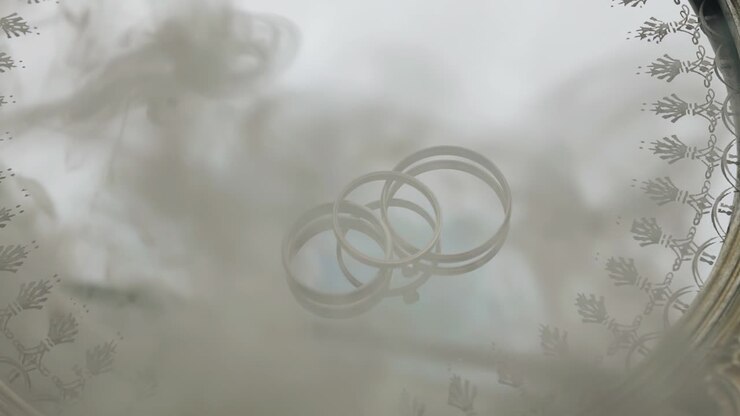 Smoke appears above the rings lying on a mirrored tray. He closes the rings with himself