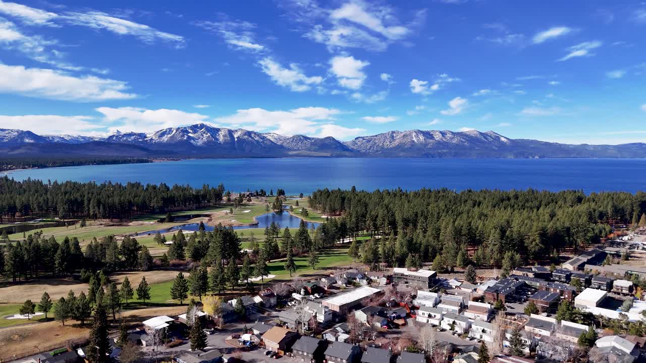 Vista aerea con drone del campo da golf e della città di South Lake Tahoe con lago blu e montagne innevate sullo sfondo