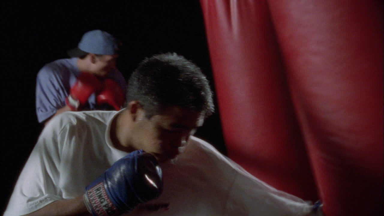 권투 선수는 샌드백에서 펀치를 연습합니다.