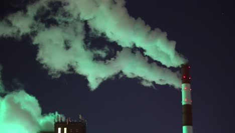 green smoke from chimney of night industrial cityscape with carbon emissions from factory