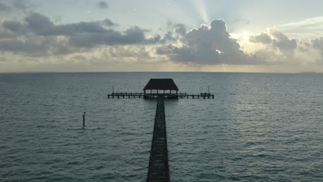 Aerial-drone-shot-over-wooden-pier-on-sea-water-in-Mexico,-North-America