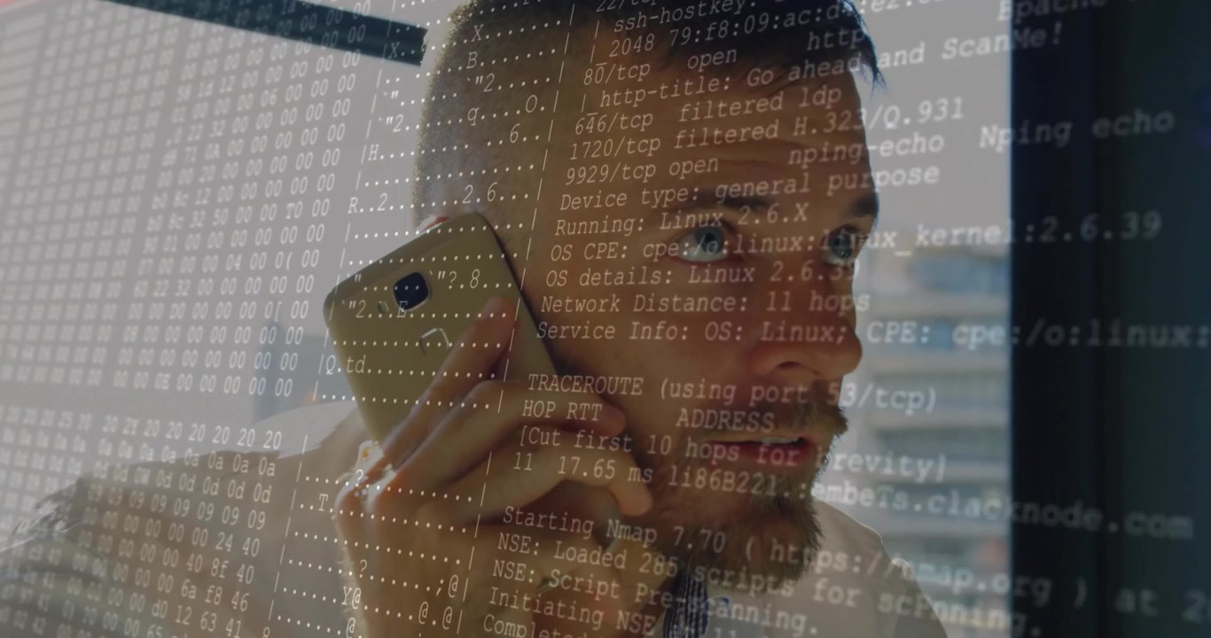 Mid male IT holding smartphone to ear while reviewing growing network scan overlay windowside