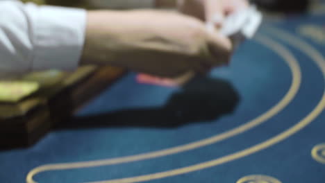 mujer crupier barajando cartas antes de jugar al póquer de cerca. distribuidor de casino