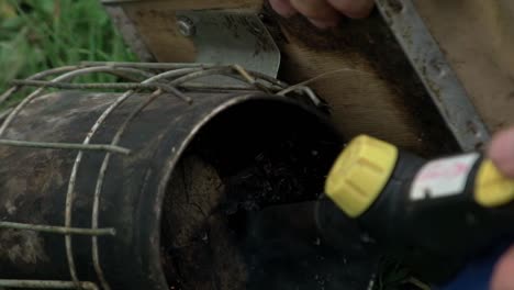 close-up shot of lighting fire in smoke tool for bees fumigation. honey bees houses. natural garden. apiculture farming.