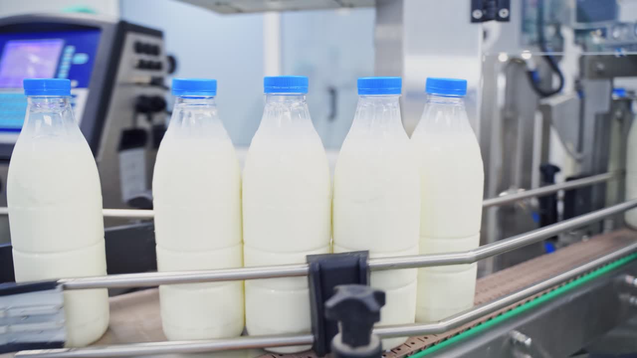 Milk production line at dairy factory. Automated production line at milk factory. Modern plant for bottling milk in plastic bottles.