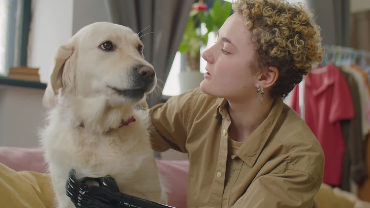 Young Woman with Prosthetic Arm Petting Dog at Home
