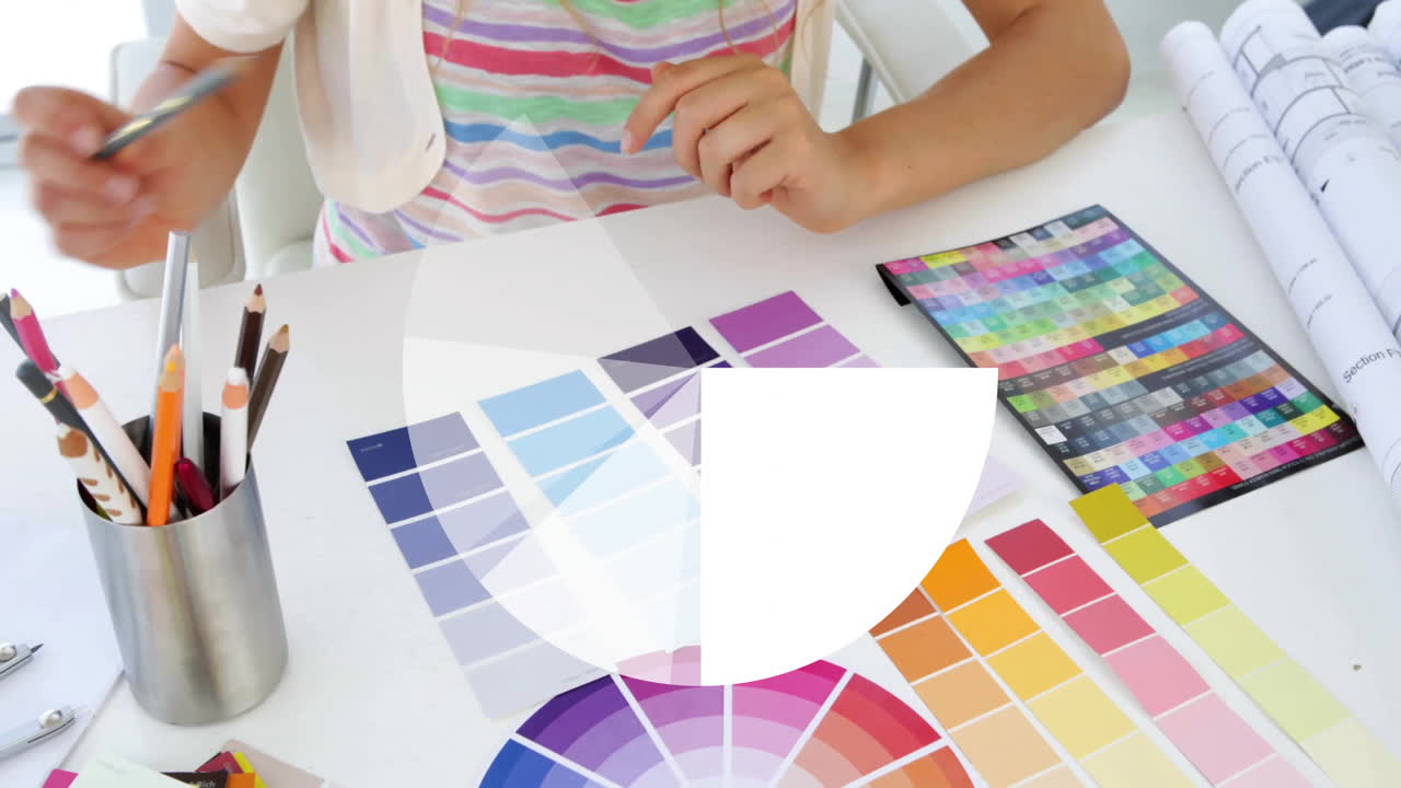 Color wheel and pie chart animation over person selecting color swatches at desk