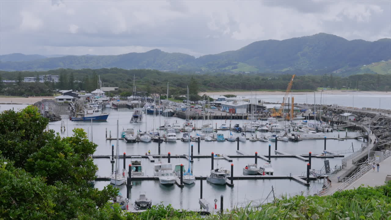 Wide shot of Coffs Harbour marina as a fishing vessel arrives back, New South Wales, Australia
